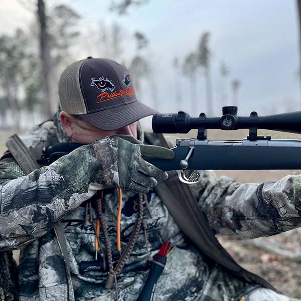 Heath Wood looking down his scope while coyote hunting