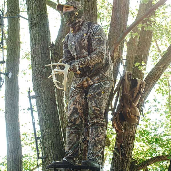 Man In A Treestand With Antlers Recreating Buck Fighting Sounds wearing blocker outdoor gear